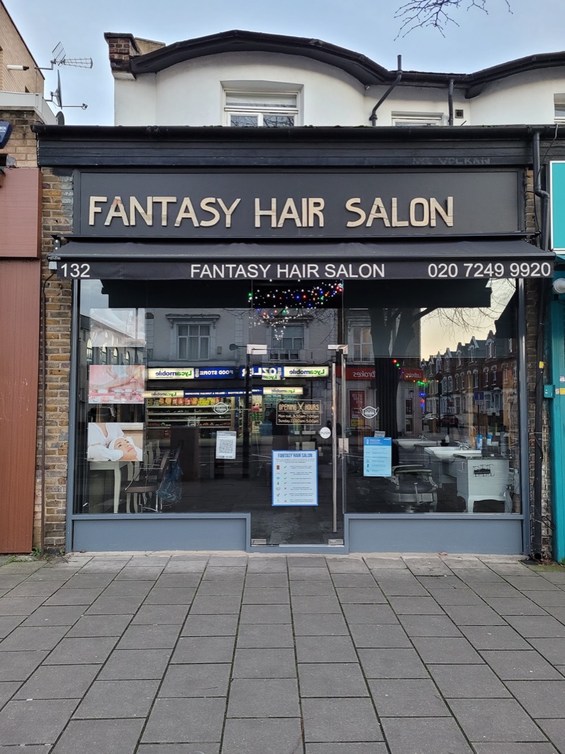 The Fantasy Hair Salon shopfront at 132 Stoke Newington Road, with its charcoal fascia and gold lettering
