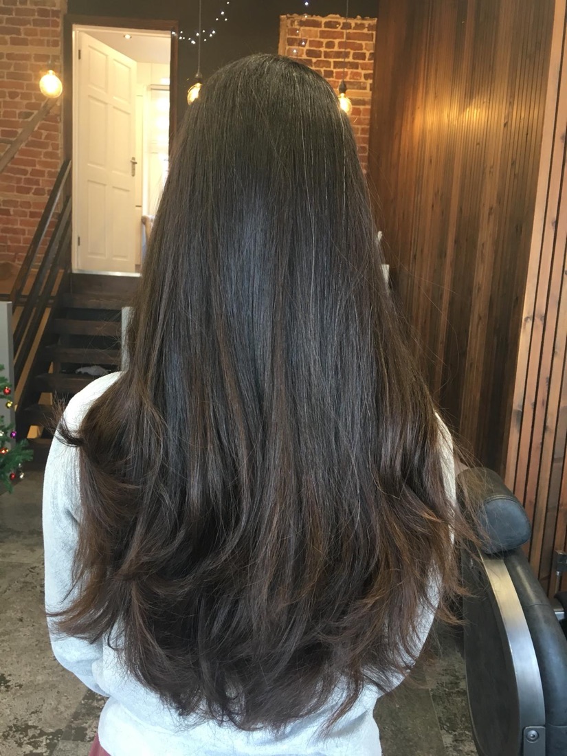 Long brunette hair with soft layers, freshly cut and blow-dried at Fantasy Hair Salon